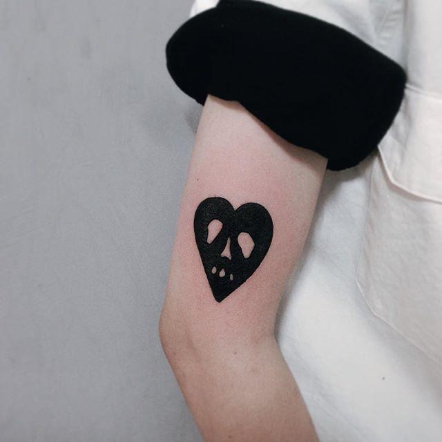 Tatuagem de coração monocromático no braço