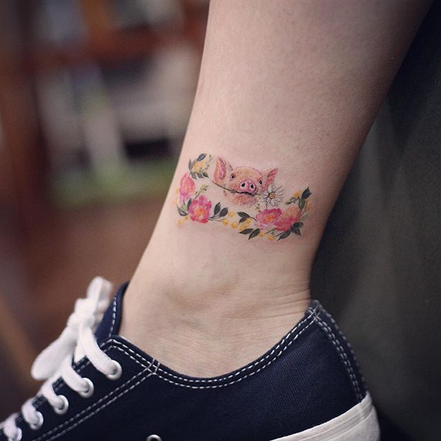 Tatuagem na perna feminina delicada: o mais fofo porquinho entre as flores!