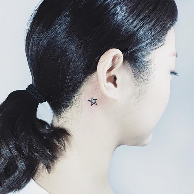 Estrela de cinco pontas atrás da orelha, discreta e simples.