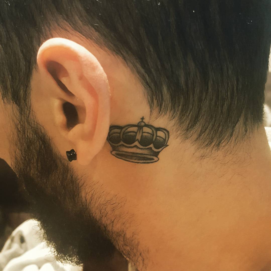  Tatuagem masculina atrás da orelha de coroa.