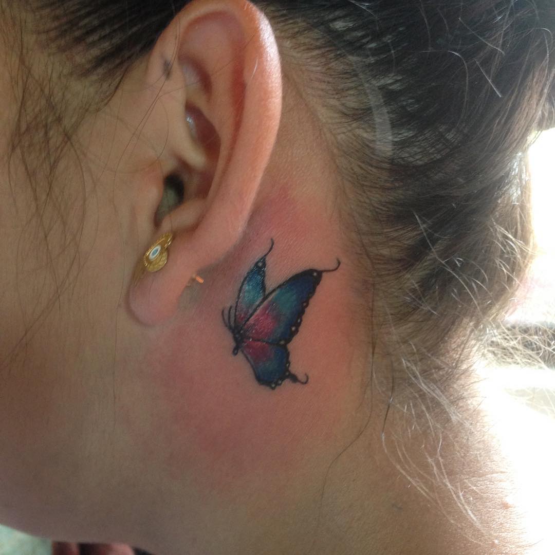 Linda borboleta tatuada atrás da orelha.
