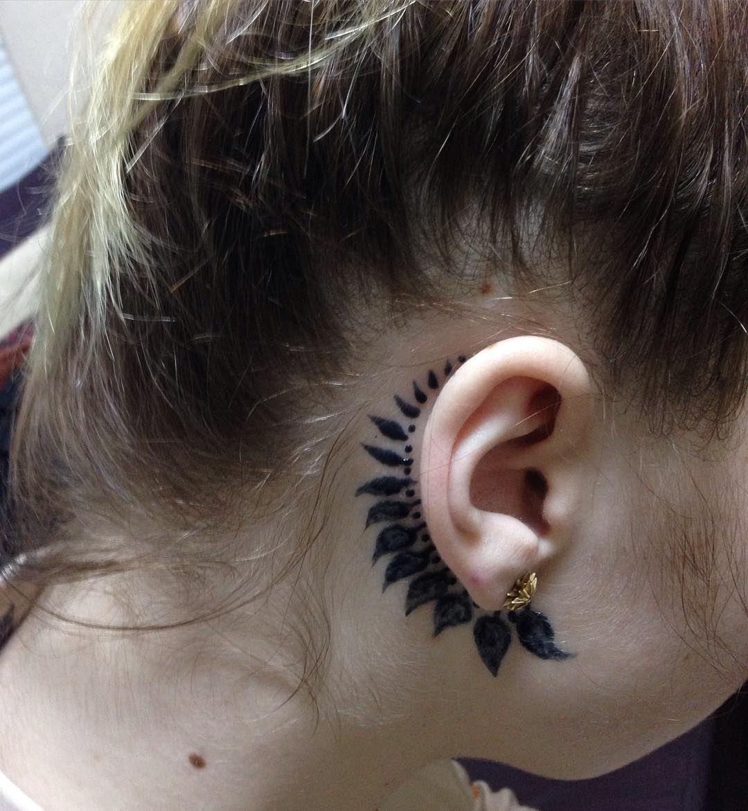 Tatuagem feminina atrás da orelha com motivo floral, linda e feminina.