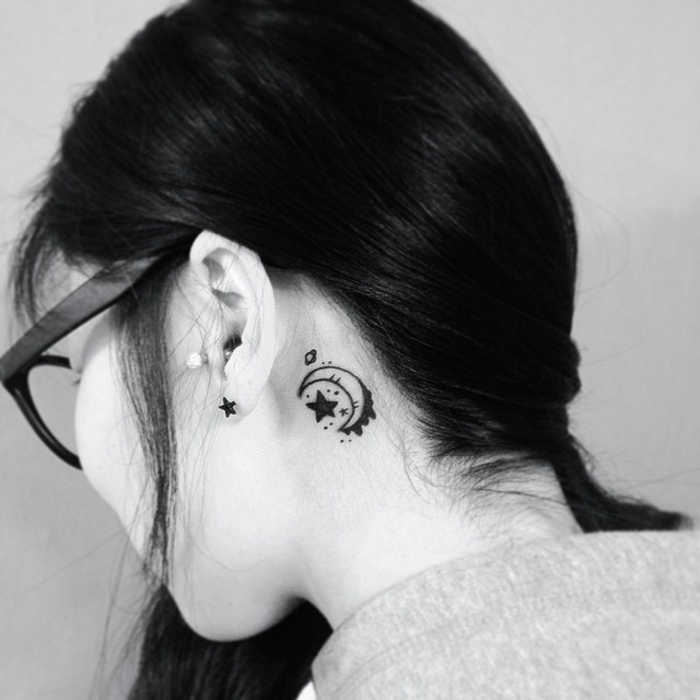 Linda e delicada tatuagem feminina atrás da orelha.