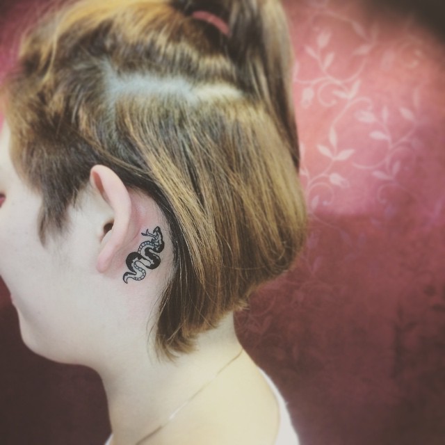 Tatuagem feminina atrás da orelha, para aquelas que preferem algo mais impactante como uma serpente.
