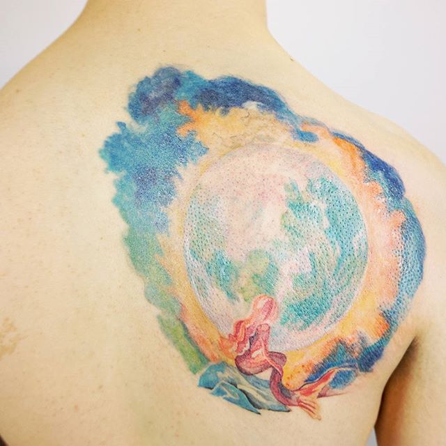 Cheio de cores uma tatuagem para costas masculina: A sereia olhando a lua, seu significado está ligado ao amor e a liberdade