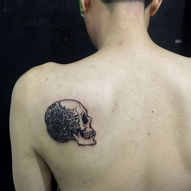 Tatuagem masculina nas costas ao estilo minimalista uma caveira com mandala