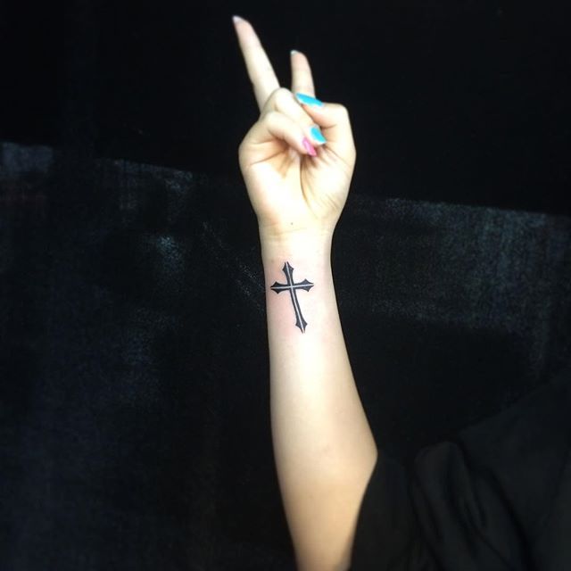 Tatuagem de cruz no punho feminina