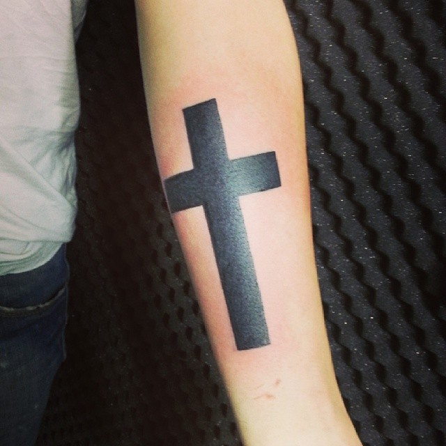 Tatuagem de cruz grossa em preto mais comum entre homens, significado religioso