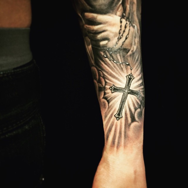 Tatuagem braço fechado com detalhe de cruz