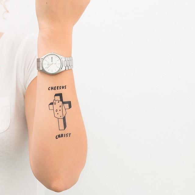 Tatuagem de cruz no braço e frase