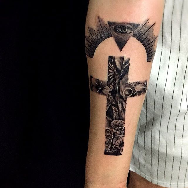 Tatuagem de cruz com muita personalidade, repleta de caveiras e coberta de misticismo 