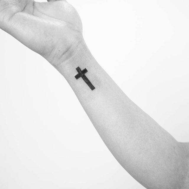 Tatuagem de cruz no punho: Risco forte em preto para os que admiram esta técnica é a melhor escolha de local e desenho