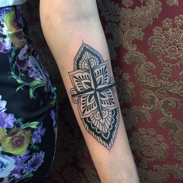 Tatuagem de cruz com adaptações voltada para um trabalho com flores e tons mais escuros