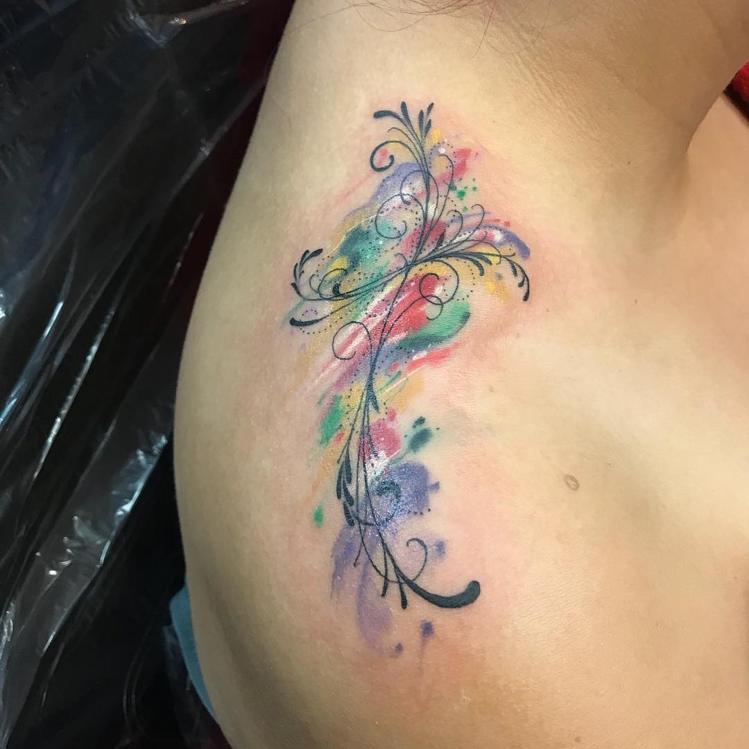 Tatuagem de cruz em aquarela com traços super finos e mais delicados