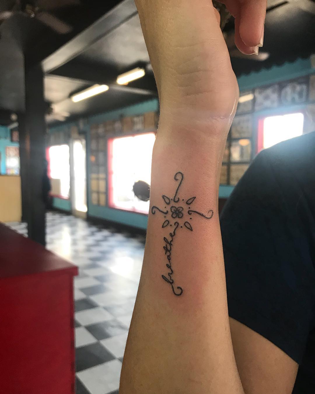 Tatuagem de cruz no pulso: Com flores e mais delicadeza para a mulher 