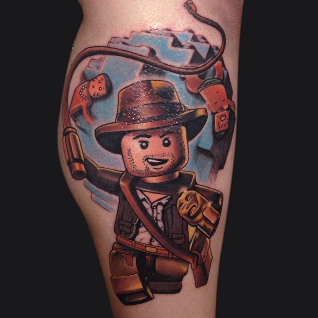 Tatuagem Boneco de Lego - inspirado no filme de Indiana Jones e no jogo Lego do mesmo personagem.