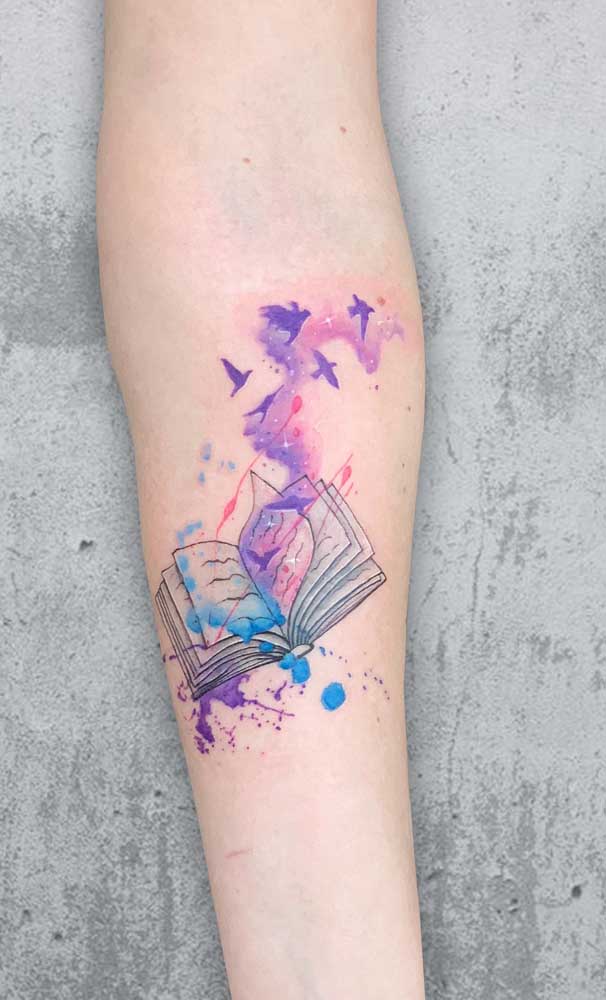 O livro é uma ótima escolha de tatuagem aquarela para os amantes da leitura.