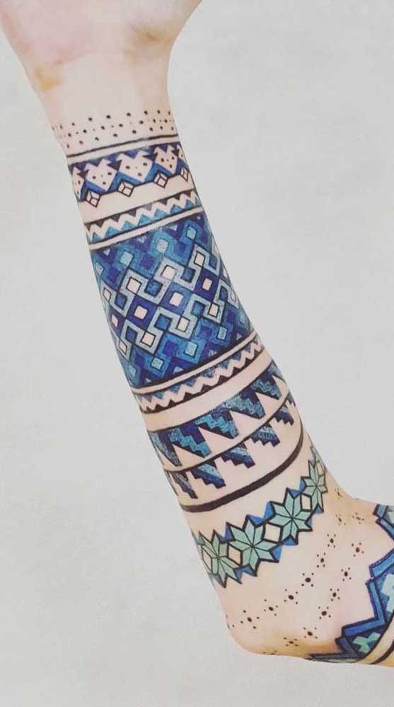 Um conjunto de tatuagens no estilo bracelete que tomam conta do braço inteiro.