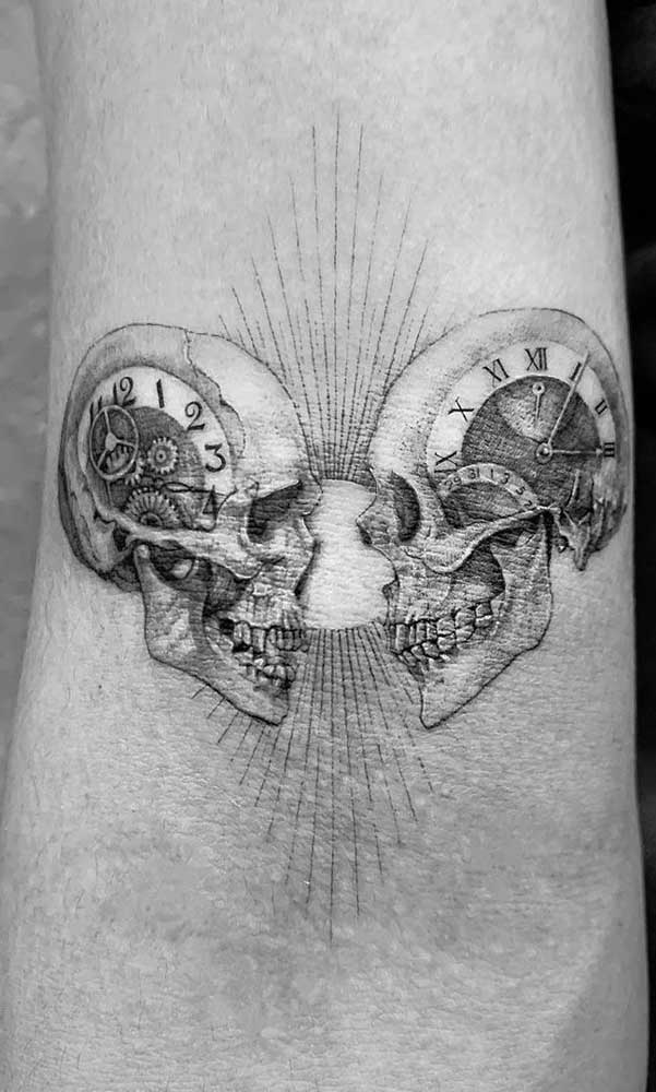 Vida e morte representada em uma tatuagem com caveira e relógio.