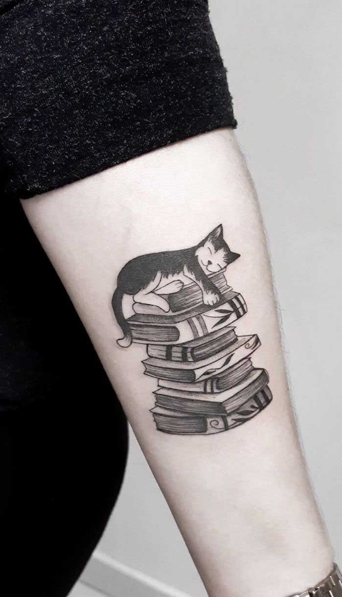 Veja que tatuagem mais fofa do gatinho em cima da pilha de livros.