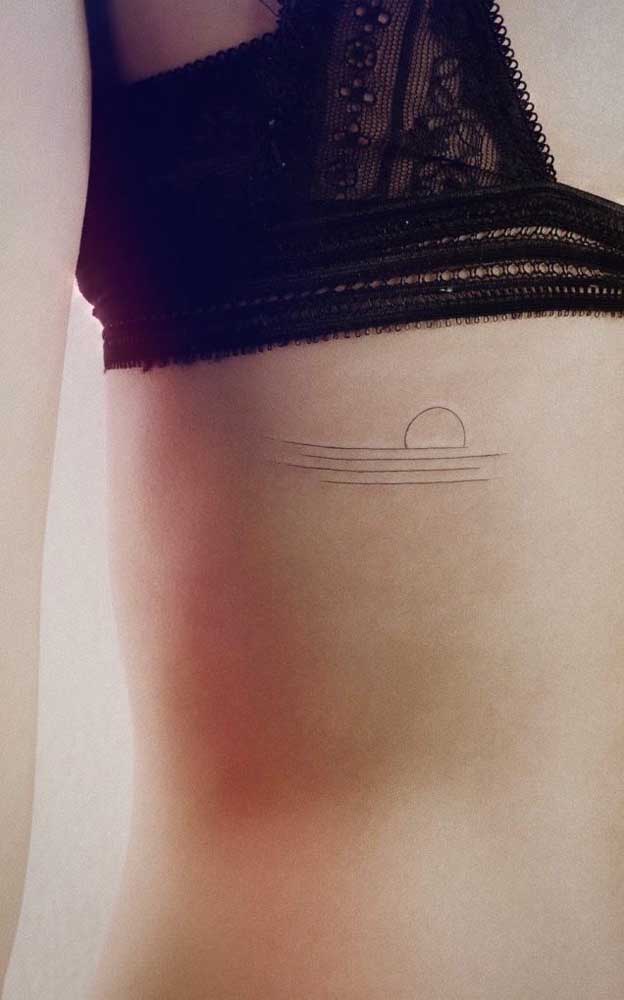 Tatuagem na costela feminina, delicada e de traços bem finos