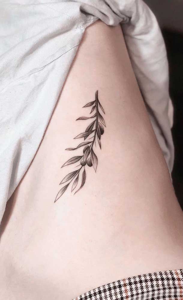 Tatuagem na costela de folhas com traço fino e delicado 
