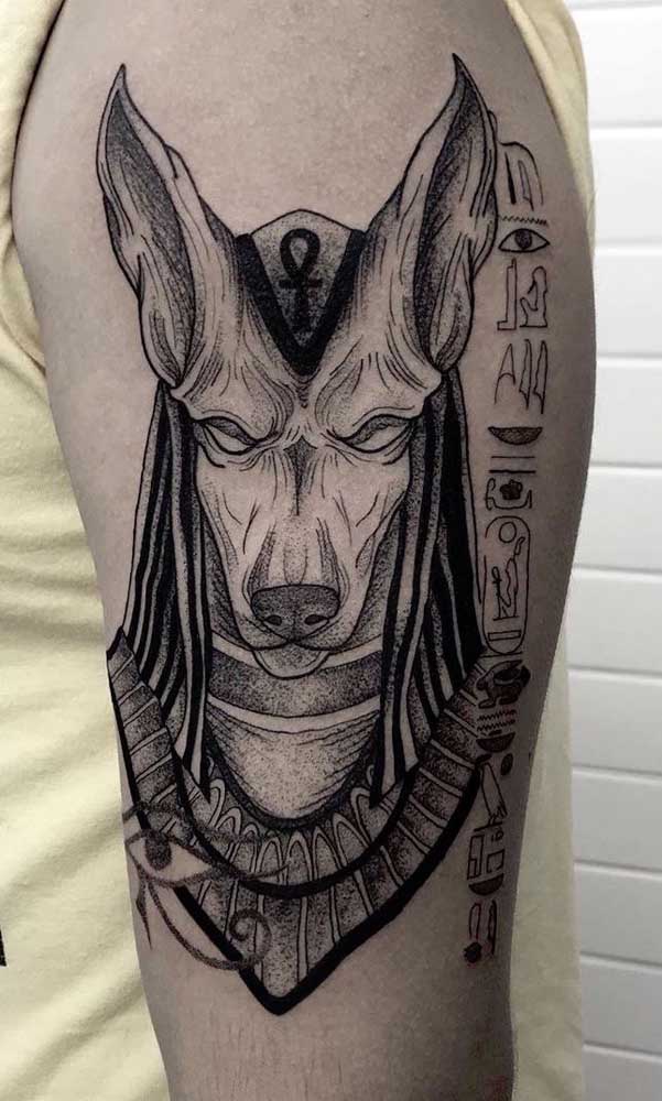Tatuagem egípcia do deus Anúbis no braço 