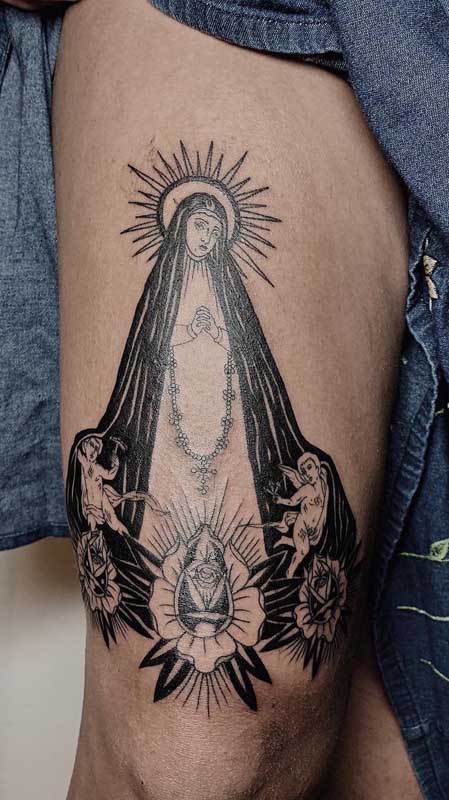 Tatuagem de santa na perna. Aqui, Nossa Senhora Aparecida surge rodeada de anjos