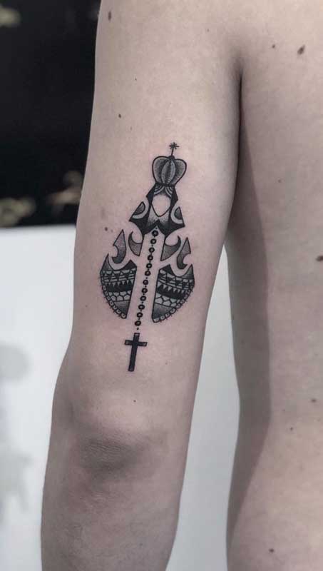 Tatuagem de santa com terço em tamanho médio no braço masculino