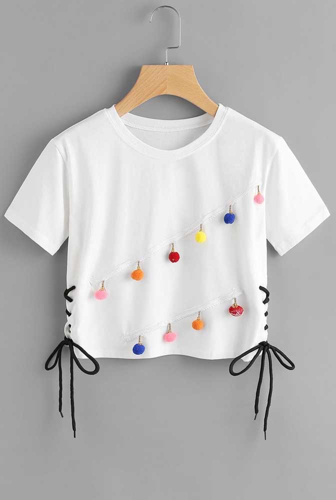 E que tal essa outra ideia de customização de camiseta? Basta um cordão de cada lado e alguns pompons