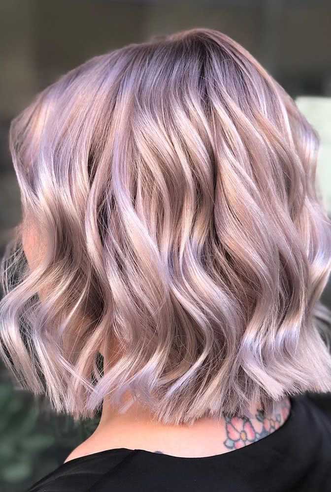 A mistura de rosa clarinho com roxo traz personalidade e combina muito com os cachos deste long bob curto, logo acima da linha dos ombros.