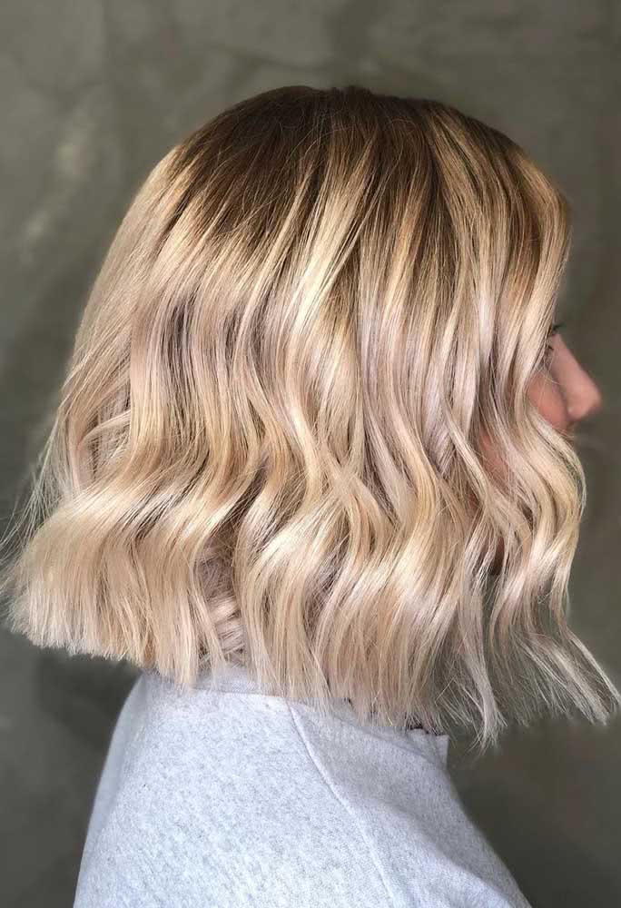 Com o cabelo mais cheio, o corte reto na linha do ombro garante mais volume para as pontas do cabelo no long bob ondulado.