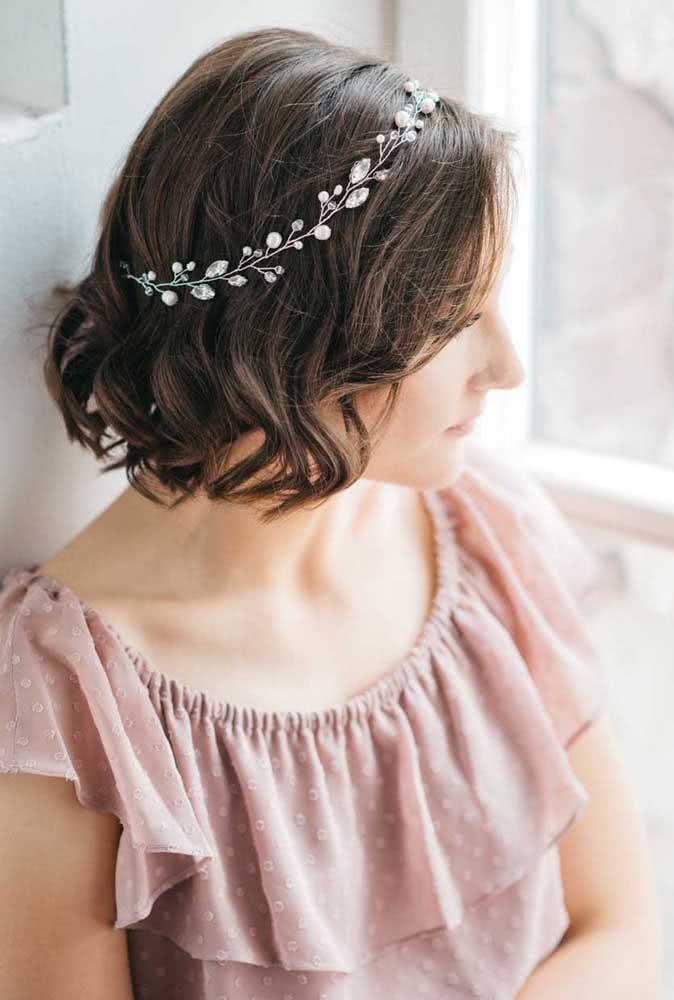 Buscando uma ideia de penteado para festas e casamentos? Adorne os cabelos soltos ondulados com uma tiara com arranjo de folhas em pedrarias.