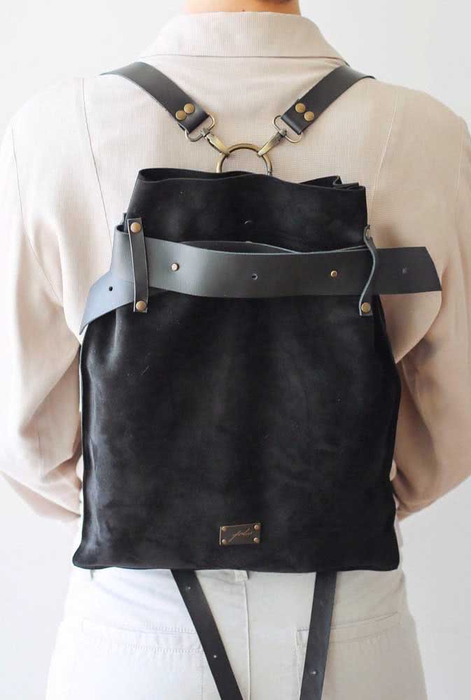 As tiras de couro garantem o fechamento e também as alças dessa mochila preta de camurça.