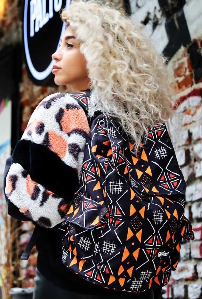 A estampa com padrão branco e laranja sobre o preto torna esta mochila feminina ainda mais estilosa.