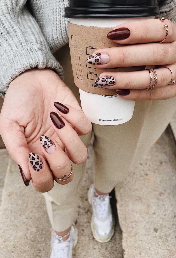 Padrão animal print de onça nas unhas gêmeas numa composição com marrom de cobertura extrabrilho, perfeita para quem segue o estilo Tumblr.