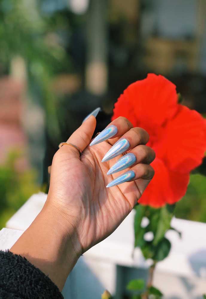 Mais uma ideia de unha stiletto grande com efeito holográfico, dessa vez com fundo azul claro. 