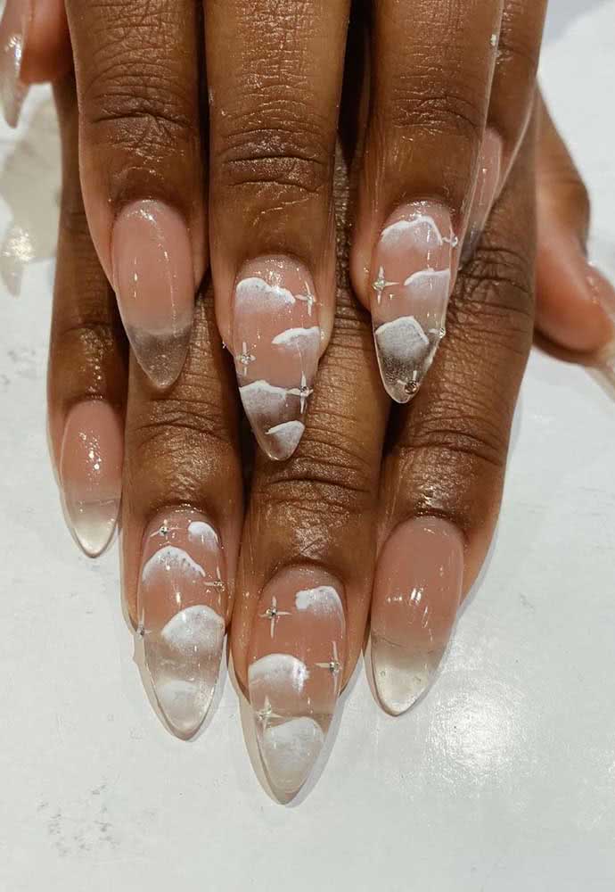 Outra ideia de unha stiletto em gel transparente, dessa vez simulando um céu com nuvens e estrelas.