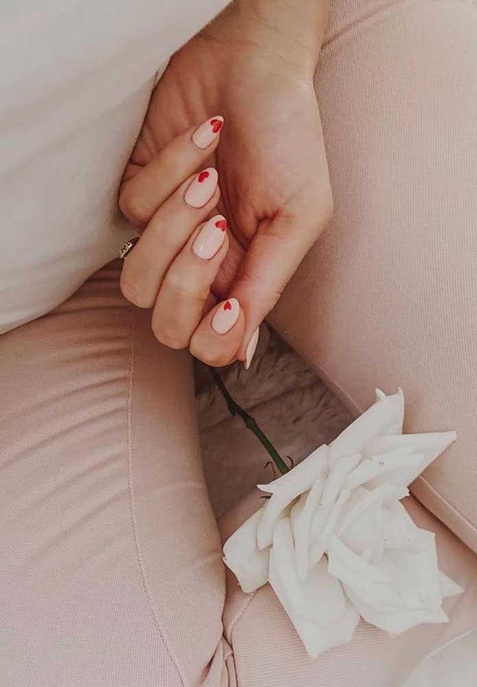 O romance está no ar com estas unhas stiletto clarinhas com coraçõezinhos vermelhos.