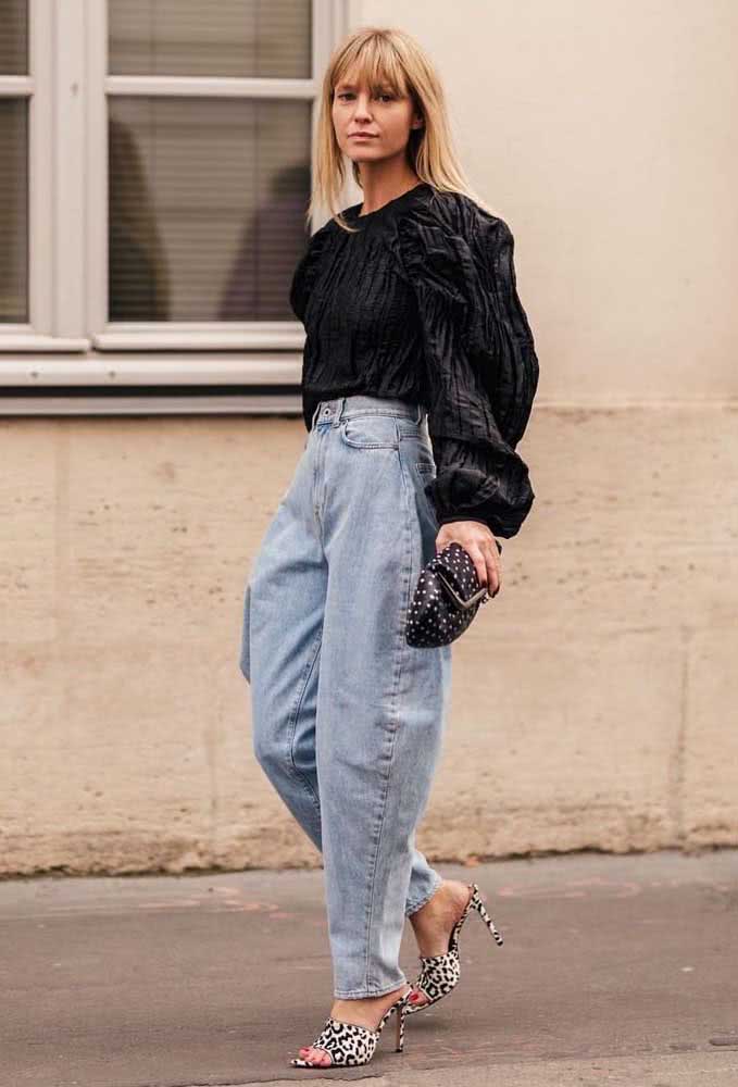 Look fashionista com calça boyfriend de cintura alta, blusa preta de mangas longas bufantes e sandália de oncinha preto e branco.