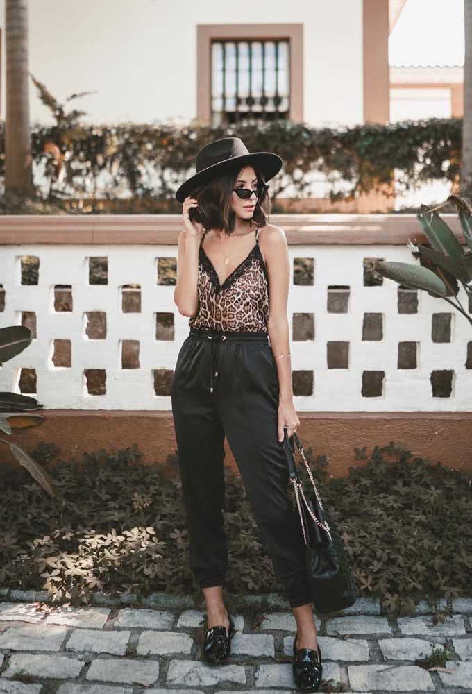 Calça jogger preta feminina com regata animal print e um chapéu para fechar o look