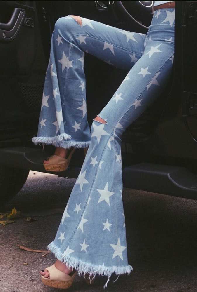 Para um look cheio de estilo, uma calça pantalona jeans com muitas estrelas e barra desfiada. 