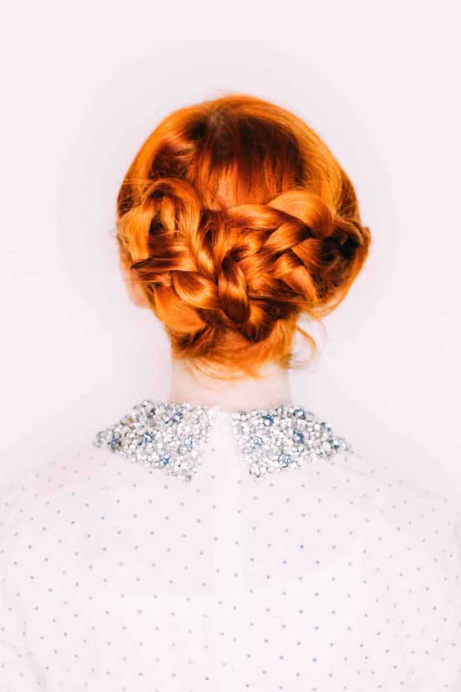 As duas tranças tradicionais se encontram e entrelaçam na parte de trás do cabelo nesse penteado preso simples, mas cheio de elegância.