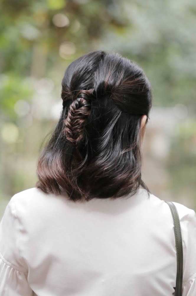 Duas mechas separadas no topo da cabeça se encontram para formar uma trança escama de peixe firme e garantir mais textura para o visual desse cabelo curto liso. 