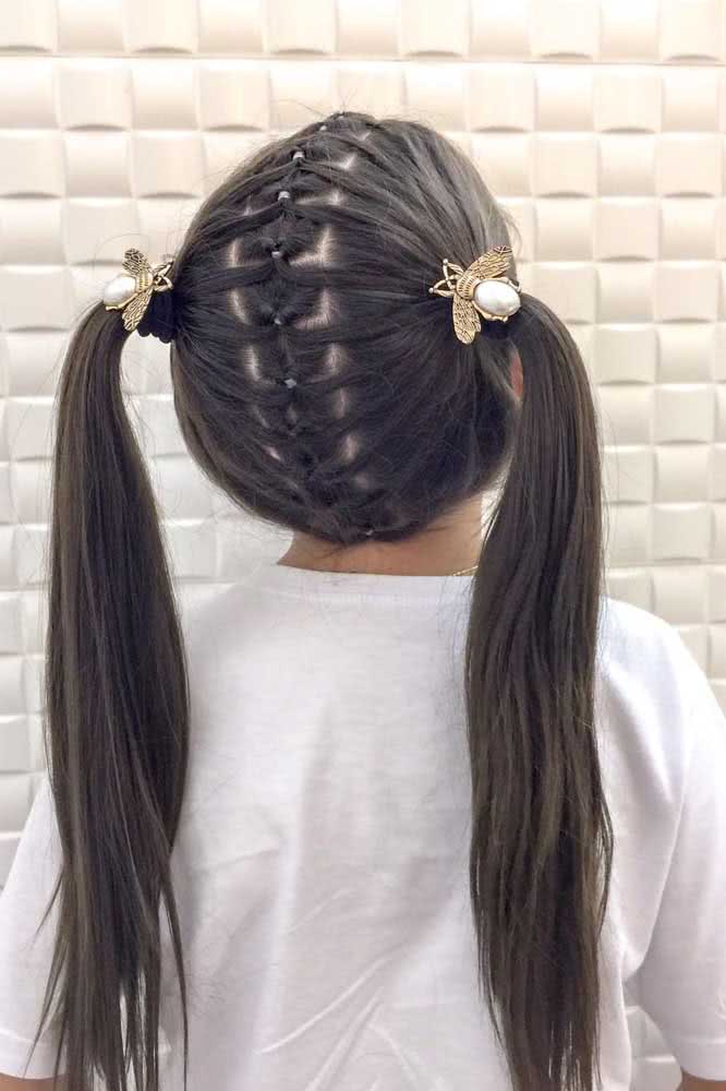 Dá uma olhada na inventividade desse penteado com trança falsa no centro, que se divide em duas maria chiquinhas num visual divertido para crianças.