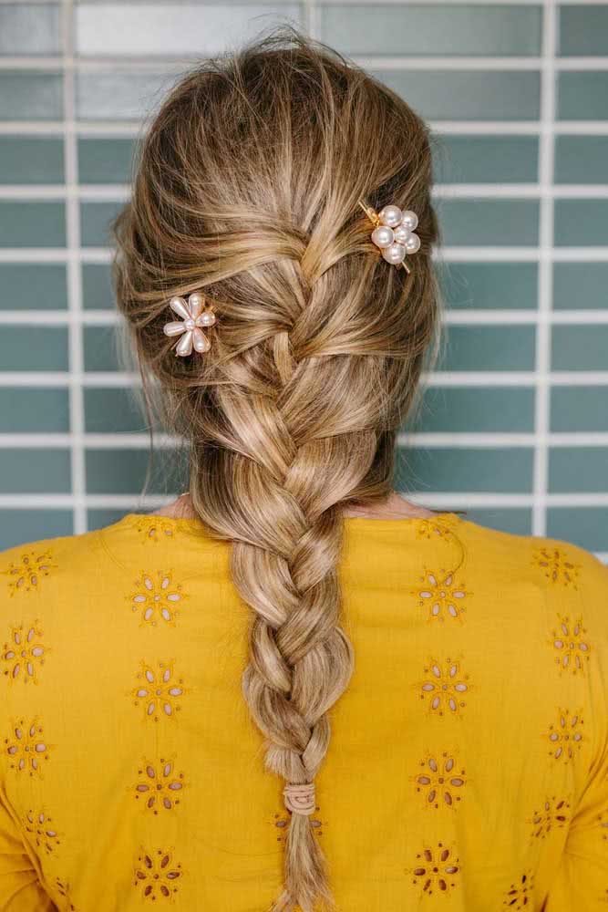 A trança embutida soltinha que continua pelo comprimento do cabelo é sempre uma boa ideia para usar no dia a dia, especialmente quando ela é adornada com presilhas decoradas.
