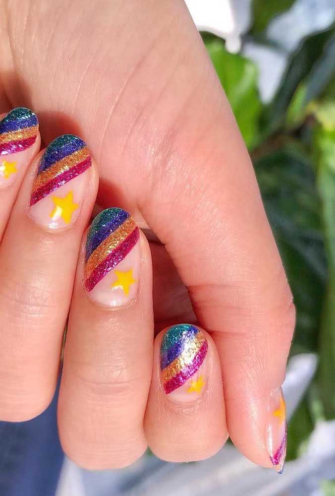 Listras diagonais e cheias de glitter nessa unha curta decorada colorida perfeita para curtir uma festa de carnaval. 