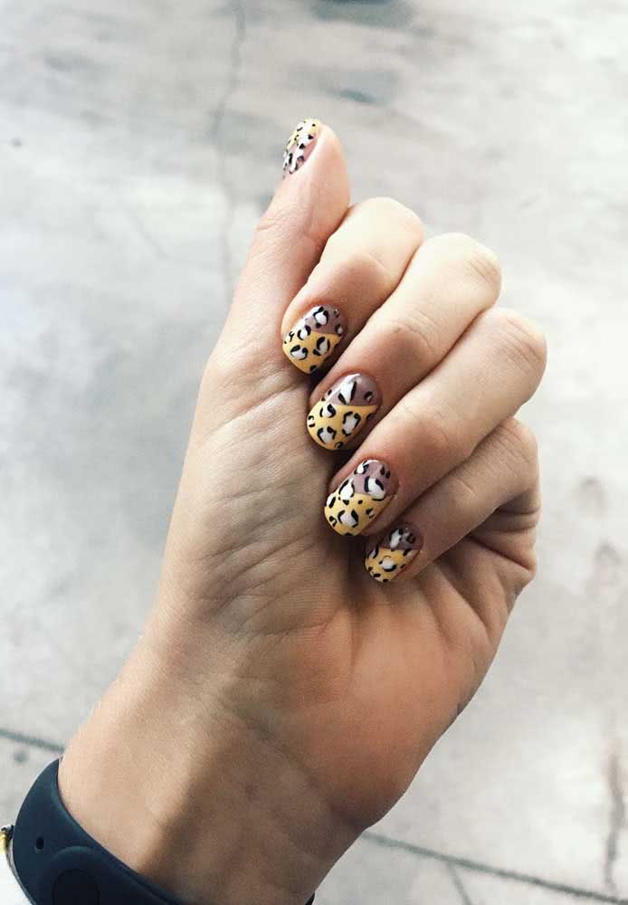 Um visual de oncinha com o fundo e as manchinhas pintadas à mão com esmalte é perfeito para quem quer ousar na sua unha curta decorada.