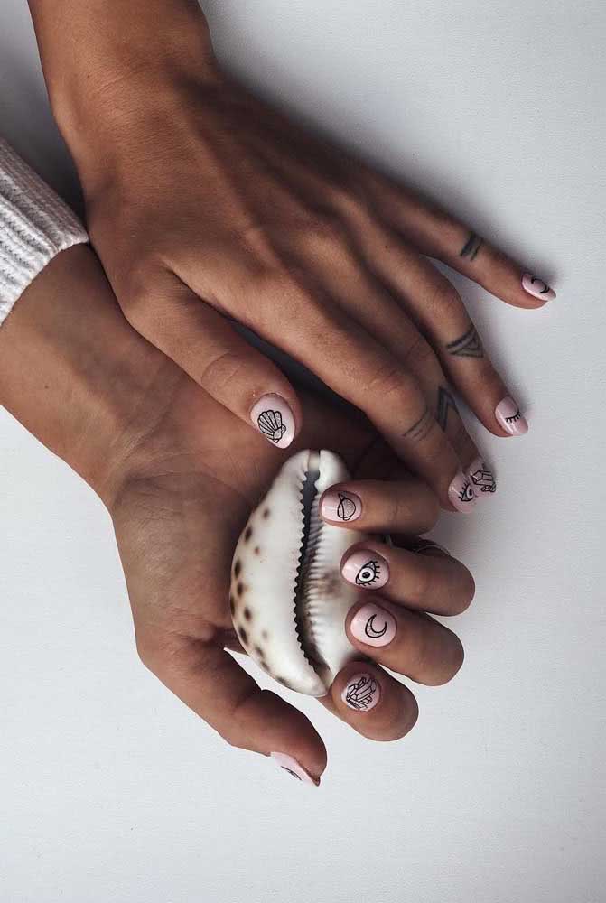 Unhas decoradas para o ano novo com símbolos e o clássico esmalte branco de fundo 