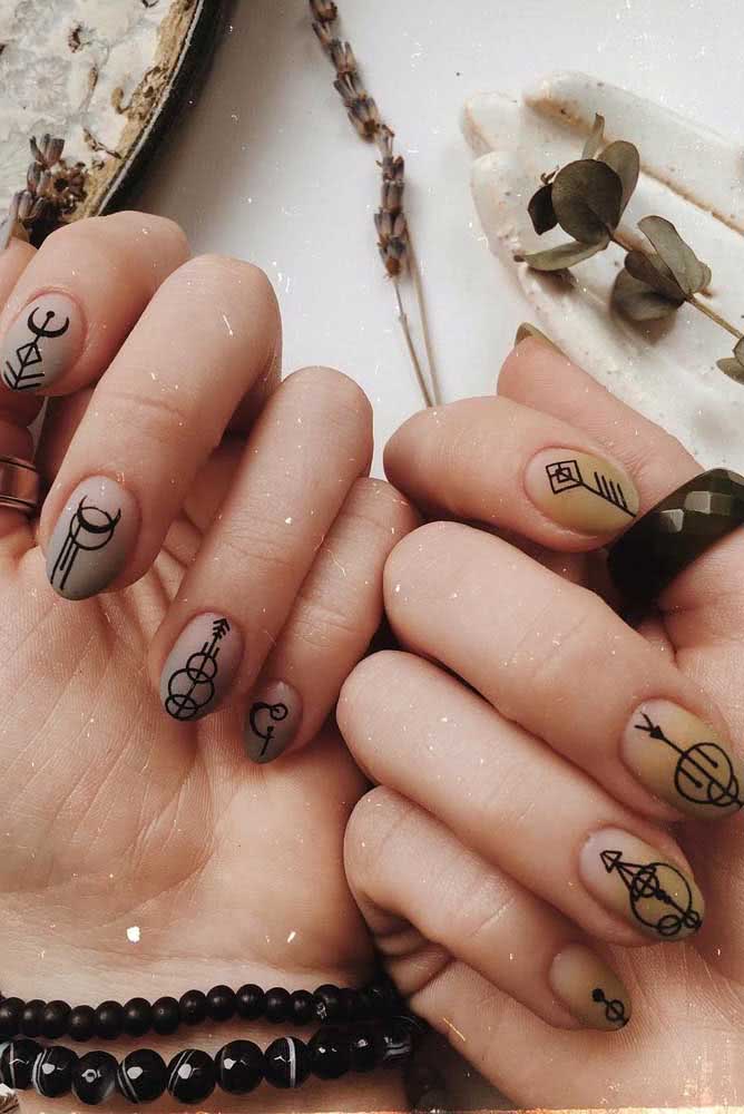 Unhas decoradas para o ano novo com símbolo dos planetas. Em uma mão, as unhas ganharam fundo prata e na outra, fundo dourado